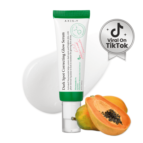 Axis-Y dark spot correcting glow serum with a papaya on a white background